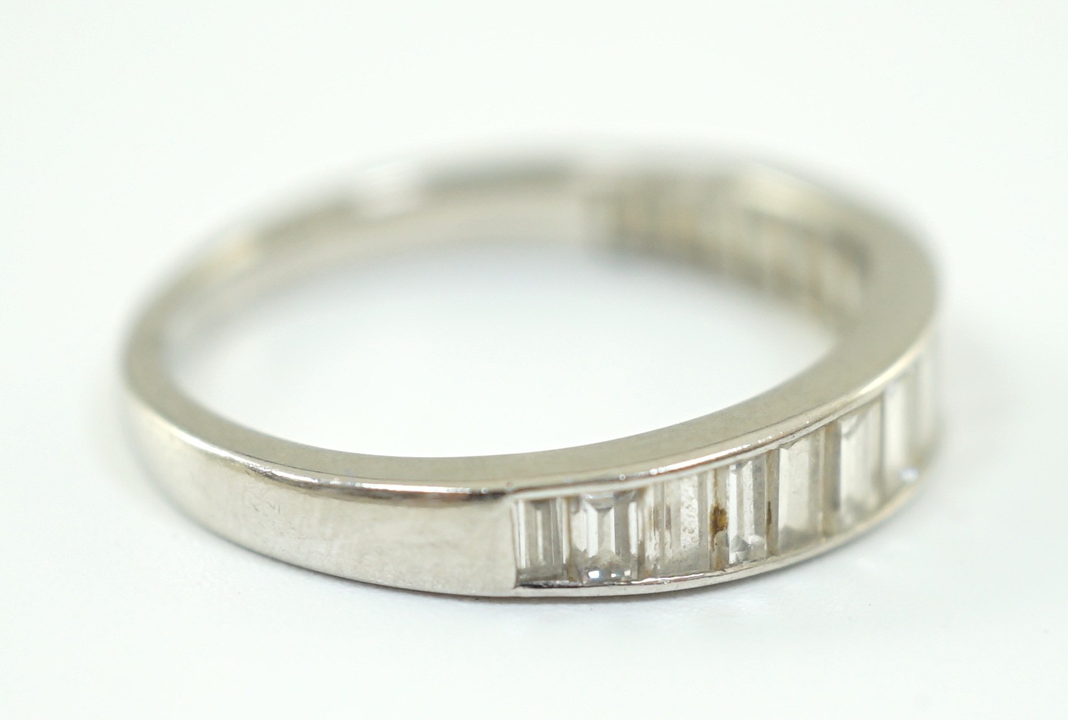 A platinum? and graduated seventeen stone baguette cut diamond set half eternity ring